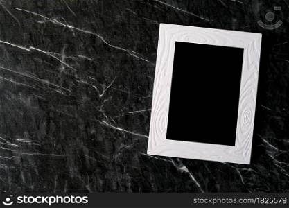 Empty white vintage wooden frame on black marble floor background, copy space for mock up and template