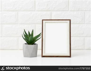 empty white wooden photo frame and flowerpots with plants on white table, white background