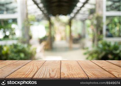 empty wood desk over blurred montage coffee shop cafe / restaurant background