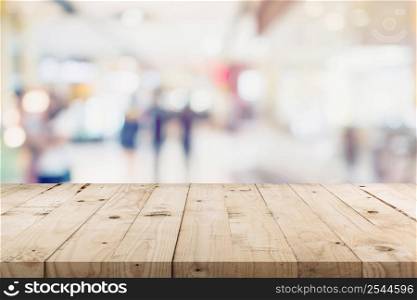 Empty wood table and People in shopping in department store. Defocused blur background, display montage for product with copy space.