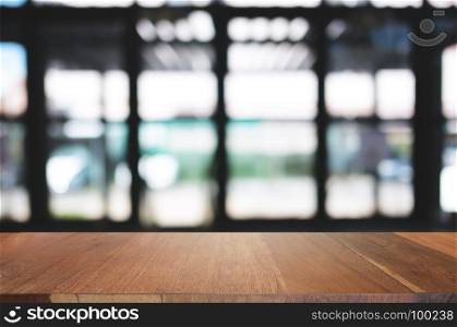 empty wood table desk in front of blurred coffee shop cafe background