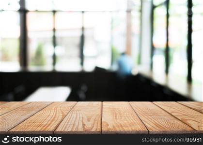 empty wood table in front of blur coffee shop / restaurant background, image can be place product