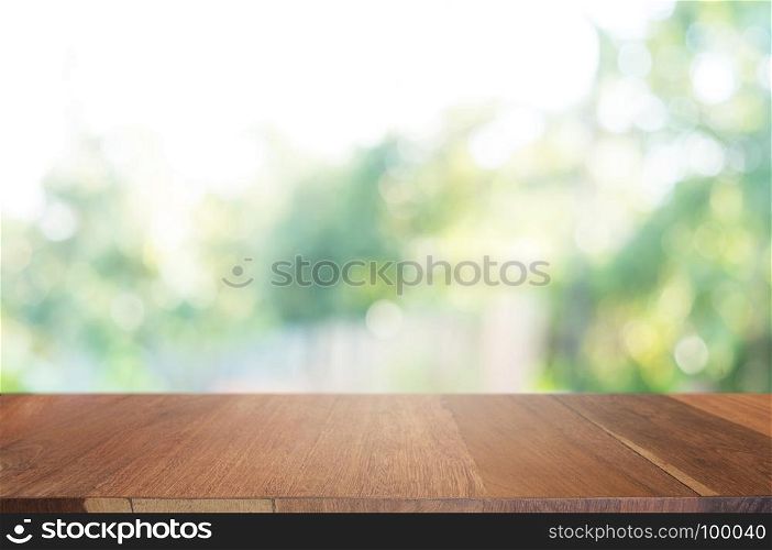 empty wood table in front of blurred montage nature in the garden background