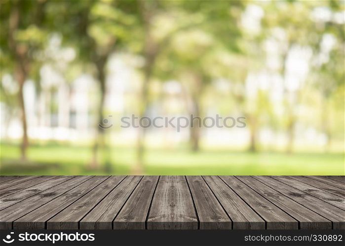 Empty wood table on blurred background copy space for montage your product or design, Blank brown board with abstract blurred background at garden