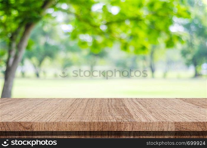 Empty wood table over blur green park nature background, tabletop, shelf, counter for product display montage