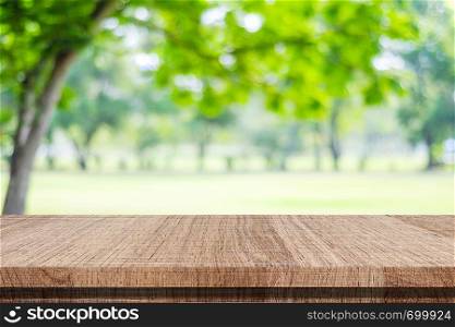 Empty wood table over blur green park nature background, tabletop, shelf, counter for product display montage