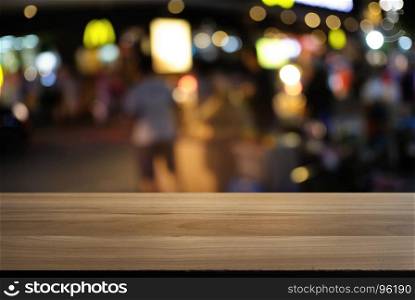 Empty wood table top and blur of night market background/selective focus .For montage product display
