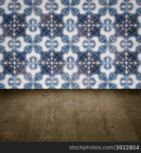 Empty wood table top and blur vintage ceramic tile pattern wall in background, Mock up template for display of your product.