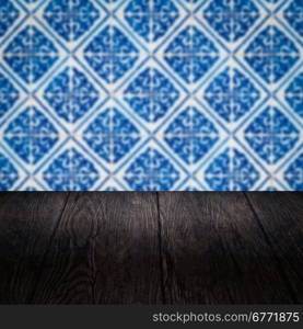 Empty wood table top and blur vintage ceramic tile pattern wall in background, Mock up template for display of your product.