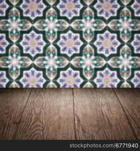 Empty wood table top and blur vintage ceramic tile pattern wall in background, Mock up template for display of your product.