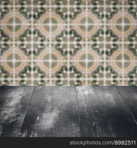 Empty wood table top and blur vintage ceramic tile pattern wall in background, Mock up template for display of your product.