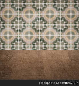 Empty wood table top and blur vintage ceramic tile pattern wall in background, Mock up template for display of your product.