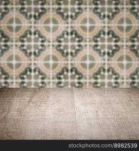 Empty wood table top and blur vintage ceramic tile pattern wall in background, Mock up template for display of your product.