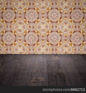 Empty wood table top and blur vintage ceramic tile pattern wall in background, Mock up template for display of your product.