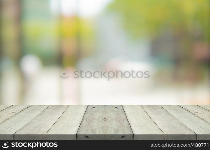 Empty wood table top on green blur background at shopping mall