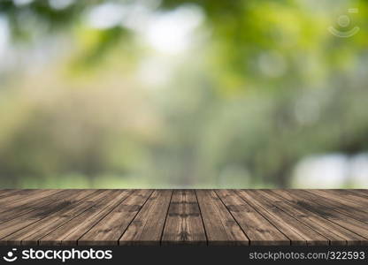 Empty wood table top on nature green blurred background at garden,space for montage show product