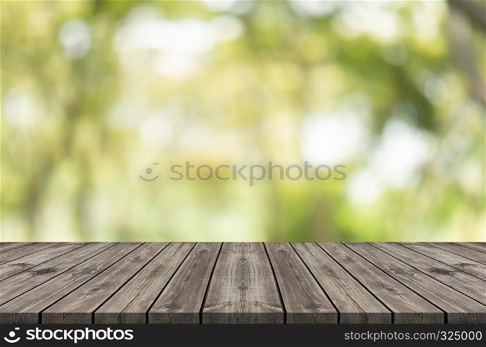 Empty wood table top on nature green blurred background at garden,space for montage show product