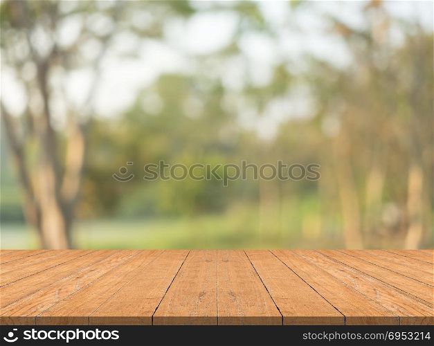 Empty wood table top on nature green blurred background at garden,space for montage show products