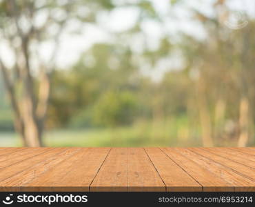 Empty wood table top on nature green blurred background at garden,space for montage show products