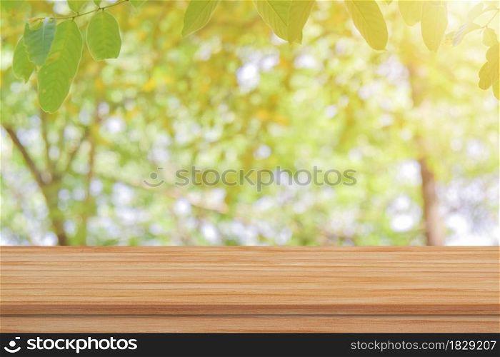 Empty wood table top over blur green nature background for product display or montage.