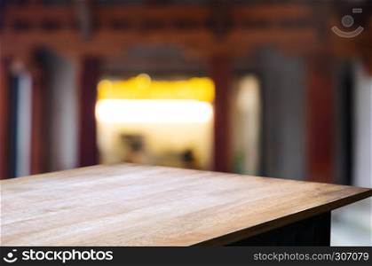 empty wood table top over blur in restaurant cafe background.
