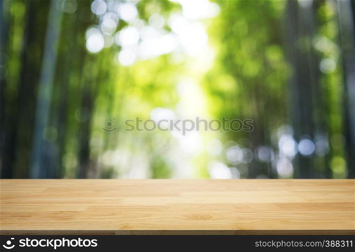 empty wood table top over blur outdoor green nature background.