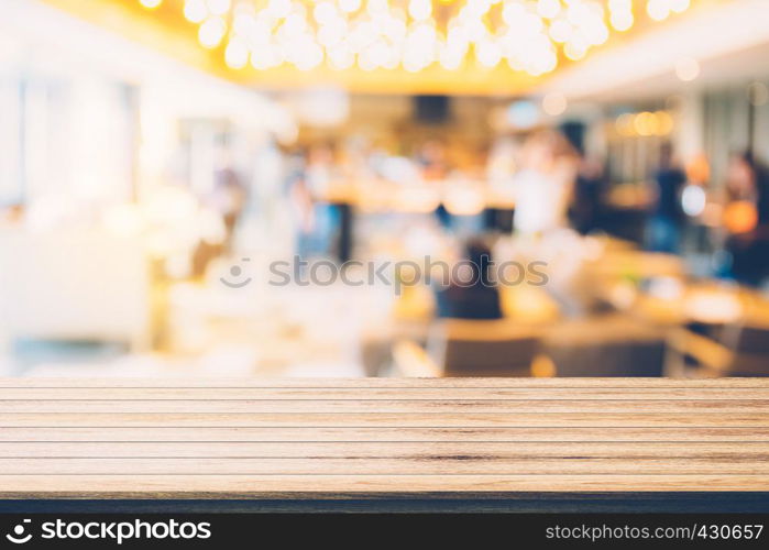 Empty wood table top with restaurant blur bokeh background - can be used for display your products.
