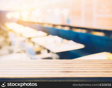 Empty wood table top with restaurant blur bokeh background - can be used for display your products.