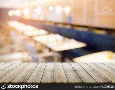 Empty wood table top with restaurant blur bokeh background - can be used for display your products.