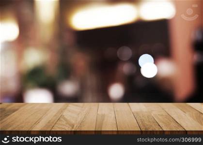 empty wood table with blur montage restaurant background.