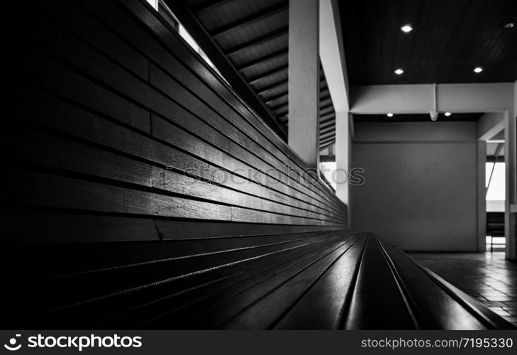 Empty wooden bench at the hotel. Perspective view of empty wooden bench on tile floor. Waiting or retirement concept. Long seat for sitting and waiting. Furniture for modern interior design. Terrace.