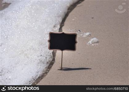 Empty wooden black sign on the beach, summer day. Empty wooden black sign on the beach