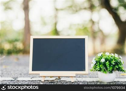 empty wooden blackboard and sphalt road texture in square shape on Road surface in the park background.