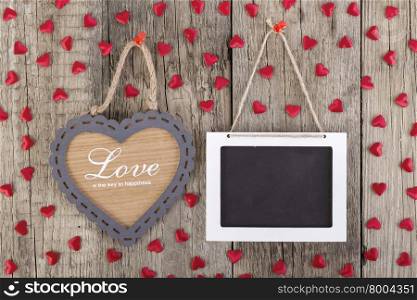 Empty wooden blackboard sign and heart shape frame whith love text on wooden background. valentines day card concept