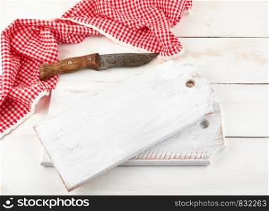 empty wooden cutting board and old knife on the white background, top view