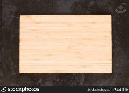 empty wooden cutting board on black background