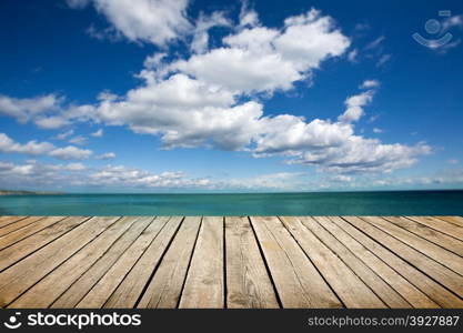 Empty wooden deck over sea and sky background