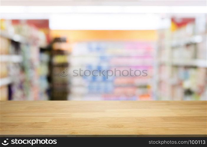 empty wooden desk in front of blurred montage hyper market background