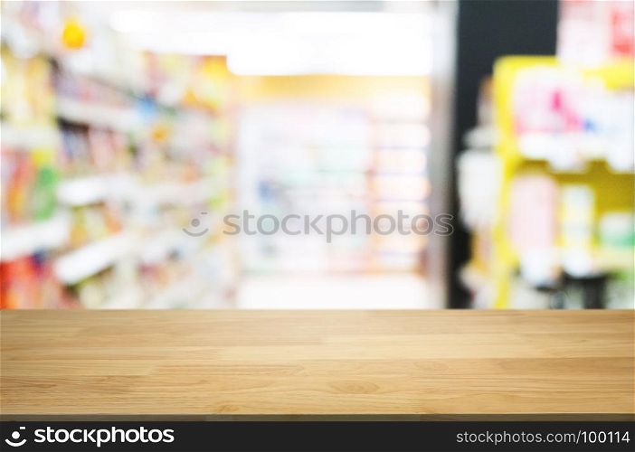 empty wooden desk in front of blurred montage hyper market background