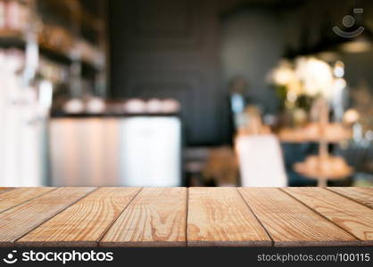 empty wooden desk over blurred coffee shop cafe background