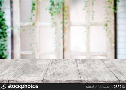 empty wooden desk over blurred interior decoration background.