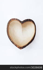 Empty wooden dish heart shape.. Empty wooden dish heart shape on white wooden background.