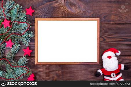 Empty wooden frame on a brown background and textile Santa Claus