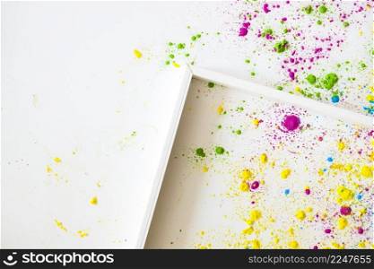 empty wooden frame white backgrounds with holi color powder