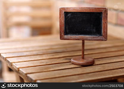 Empty wooden plate on wooden table in a restaurant, copy space for example reserved. High quality photo.. Empty wooden plate on wooden table in a restaurant, copy space for example reserved. High quality photo