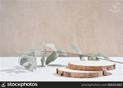 empty wooden round podium and eucalyptus branch. pedestal showcase display for product presentation. natural eco packaging promotion. empty wooden round podium and eucalyptus branch. pedestal showcase display for product presentation. natural eco packaging promotion.