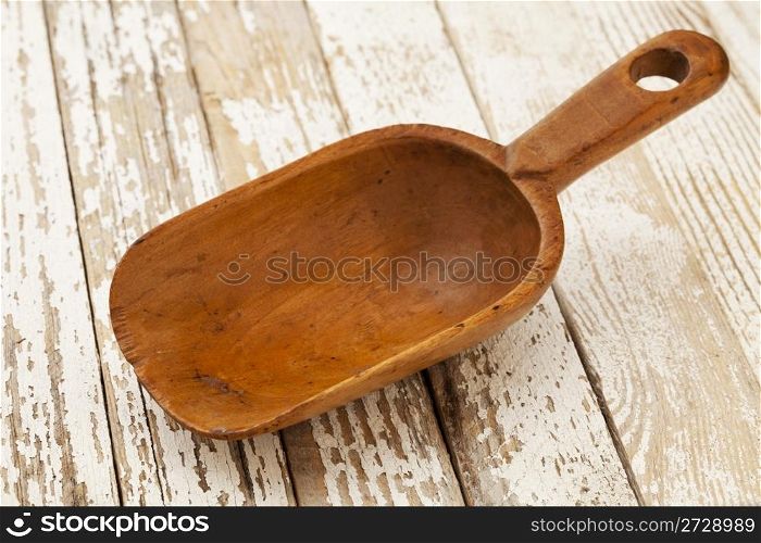 empty wooden rustic scoop on a grunge wood surface with peeling off white paint