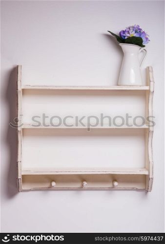 Empty wooden shelf with three hooks on the isolated background. Empty kitchen shelf