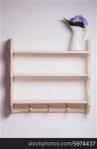 Empty wooden shelf with three hooks on the isolated background. Empty kitchen shelf