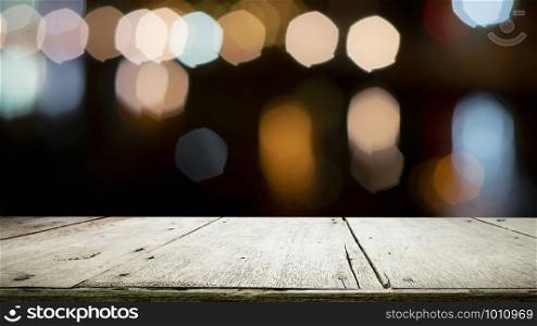 Empty wooden table for present product on coffee shop or soft drink bar blur background with bokeh image.